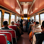 **

A vibrant, slightly crowded scene inside a Moroccan bus. Focus on the mix of people – tourists and locals in traditional clothing. Luggage piled overhead. Warm, sunny lighting streaming through the windows. The bus is heading toward a desert landscape visible through the front window.  Emphasis on the "authentic" feel of local travel.

**